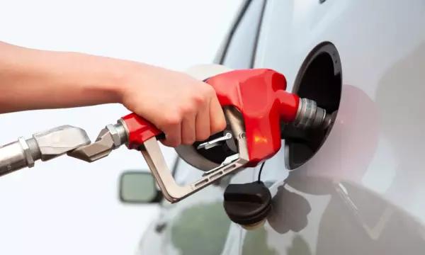 Photo of Hand holding a gas pump handle pumping gas into a vehicle