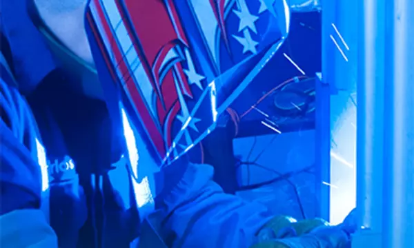 person welding with a blue background