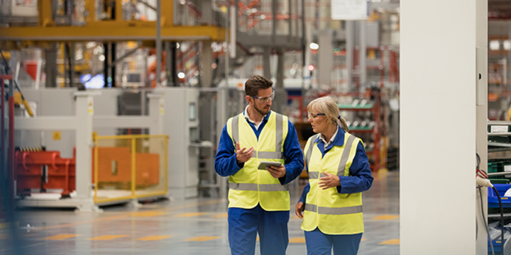 Workers walking through a factory having a discussion