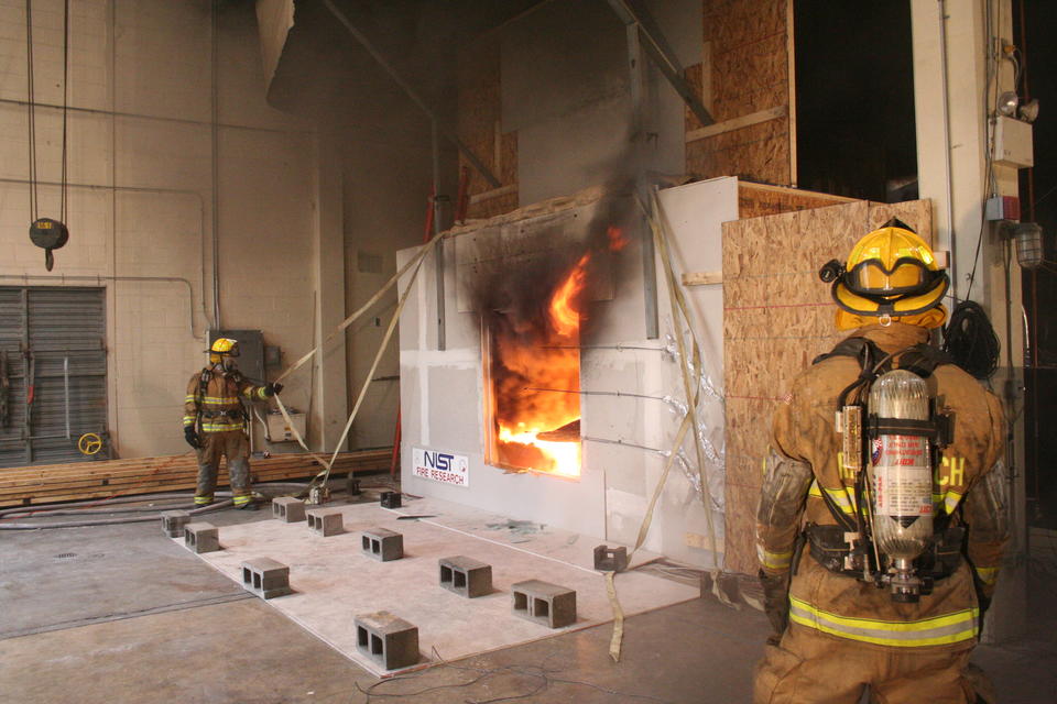 Firefighters outside a NIST test facility for examining  the impact of wind on fire spread