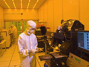 Man in a clean suit stands in front of a chip oven