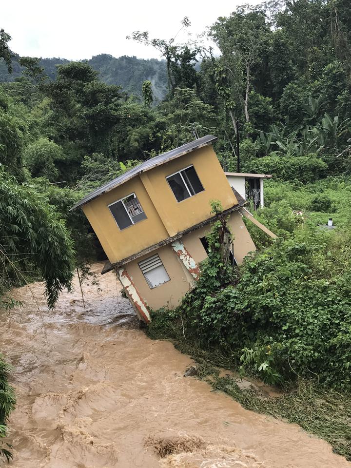 Home tilting into a river in Utuado, Puerto Rico