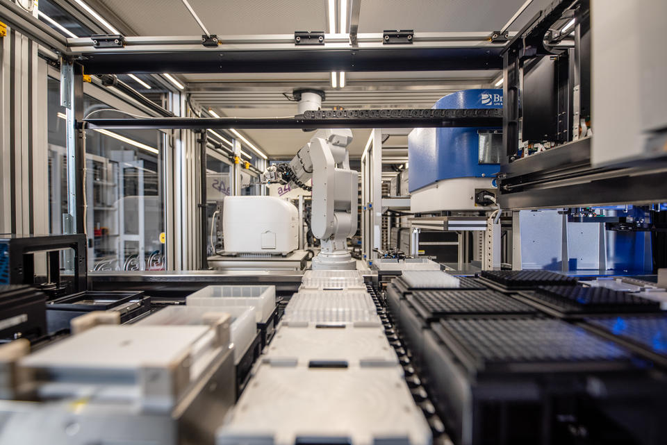 A robotic arm within the NIST Living Measurement Systems Foundry moves testing wells from one part of the system to another.