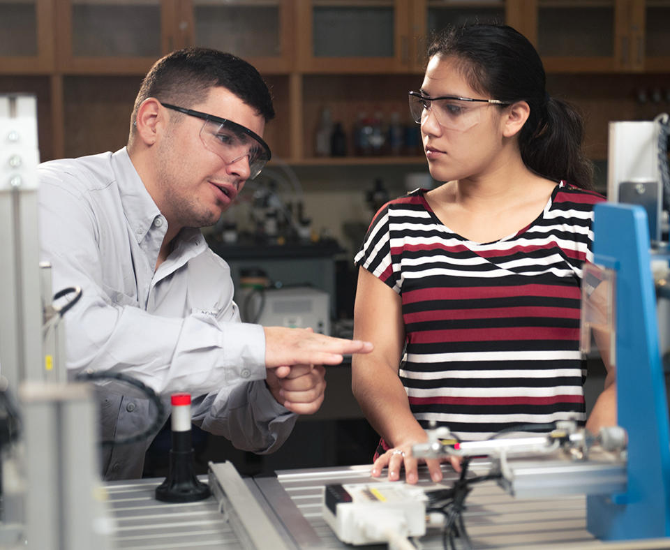 Alamo Colleges District  photo showing a teacher explaining how workshop equipment functions to a student.