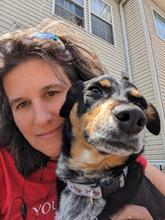 Robin Materese poses outdoors with her dog for a casual headshot. 