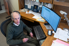 Alexander Kramida looks up as he sits at his desk in front of a computer screen full of data.