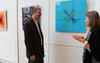 Woman and man talking beside wall with several square illustrations of science art