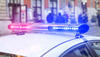 Stock photo of police lights atop a police car on a crowded street