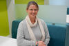 Justyna Zwolak poses smiling, seated at a colorful workspace in the NIST library. 