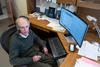 Alexander Kramida looks up as he sits at his desk in front of a computer screen full of data.