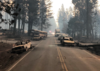 A two-lane highway lined with the burnt remains of vehicles that were destroyed by fire while in traffic..